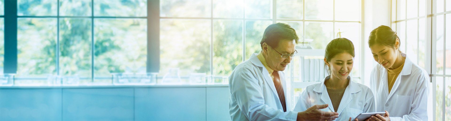 Three laboratory researchers looking at tablet