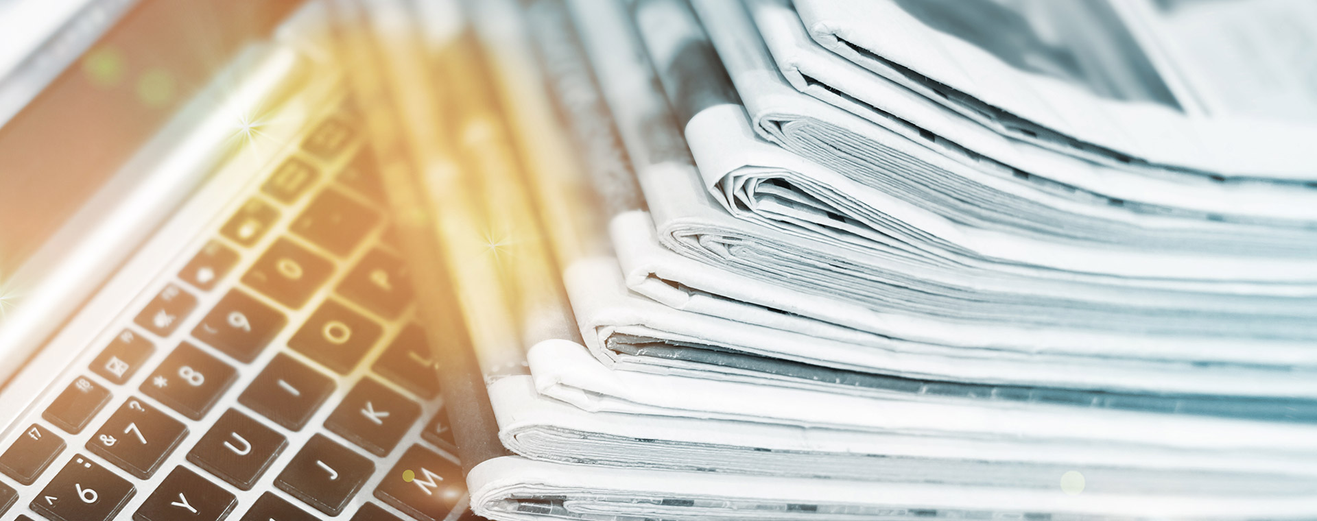 Stack of newspapers on top of a laptop
