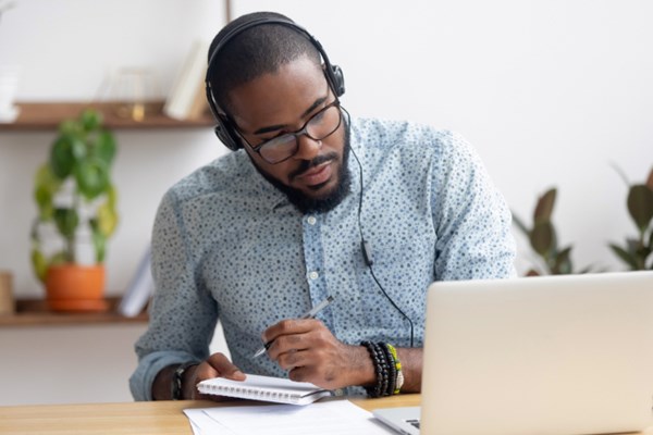Man taking notes watching a webinar